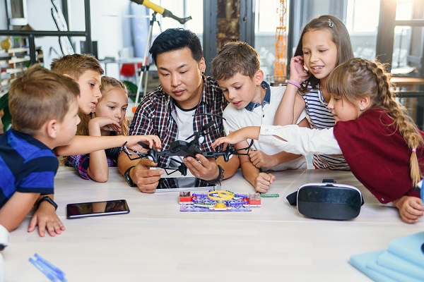 A teacher and pupils using a drone 