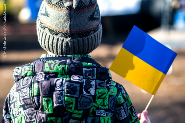 A boy holding the flag of Ukraine