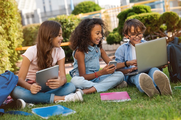 Children laughing together at a laptop