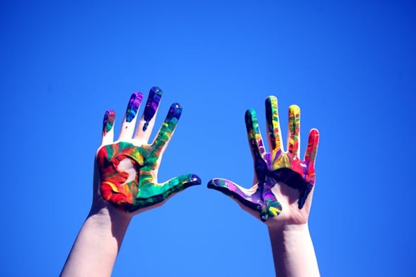 Colourful hands raised up in the air