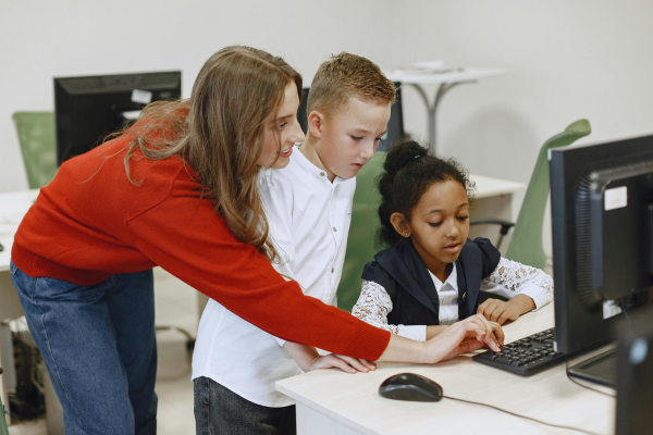 kids and teacher using computer