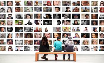 3 people looking at a picture with many different type of people