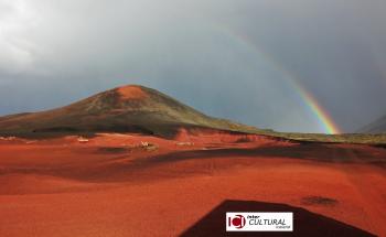 Picture of a volcano under the rain bow and the ICI logo