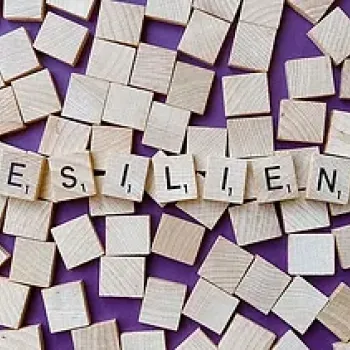 Word resilient spelled on wooden cubes on top of scattered blank wooden cubes