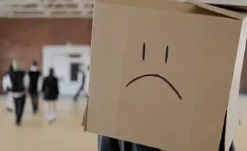 An isolated person wearing a box on the head with a sad face