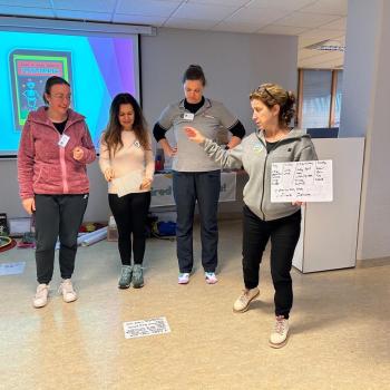 A group of teachers making gestures and smiling whilst practicing our methodology