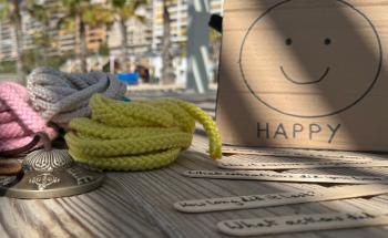 Course material made of natural materials for practicing positive teaching, with palm trees in the background
