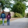 Two girls walking to school hand-in-hand