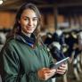 Young woman on dairy farm with tablet