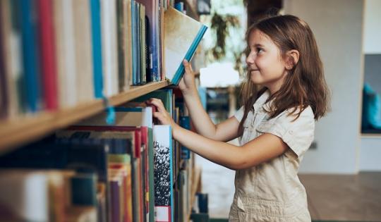 girl picking book off shelf