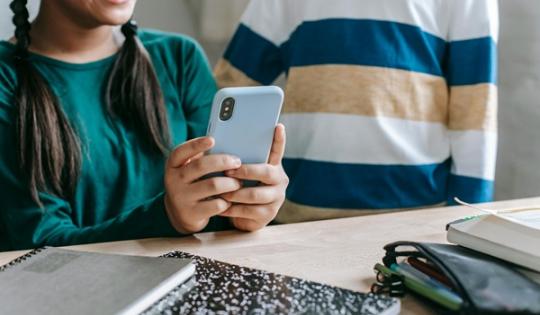 Two children looking at a mobile phone