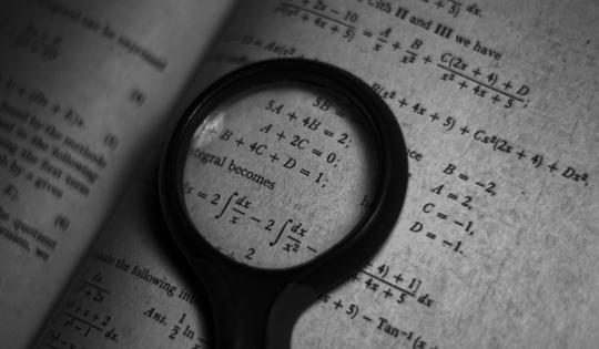 Magnifying glass over mathematical calculations