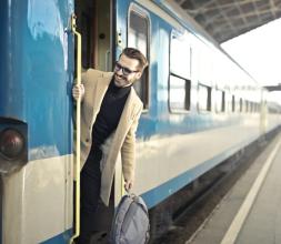 Man wearing beige overcoat inside train