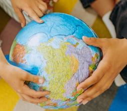 Children's hands holding a globe