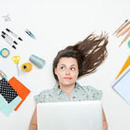 A woman on her back with blocks and crayons around