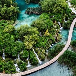 Plitvice lakes in Croatia, a trail surronded by waterfalls and lush trees