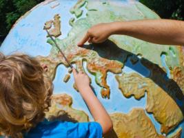 A child looking at countries on a world globe. 