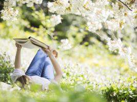 Reading a wonderful book in a `sea` of blooming trees